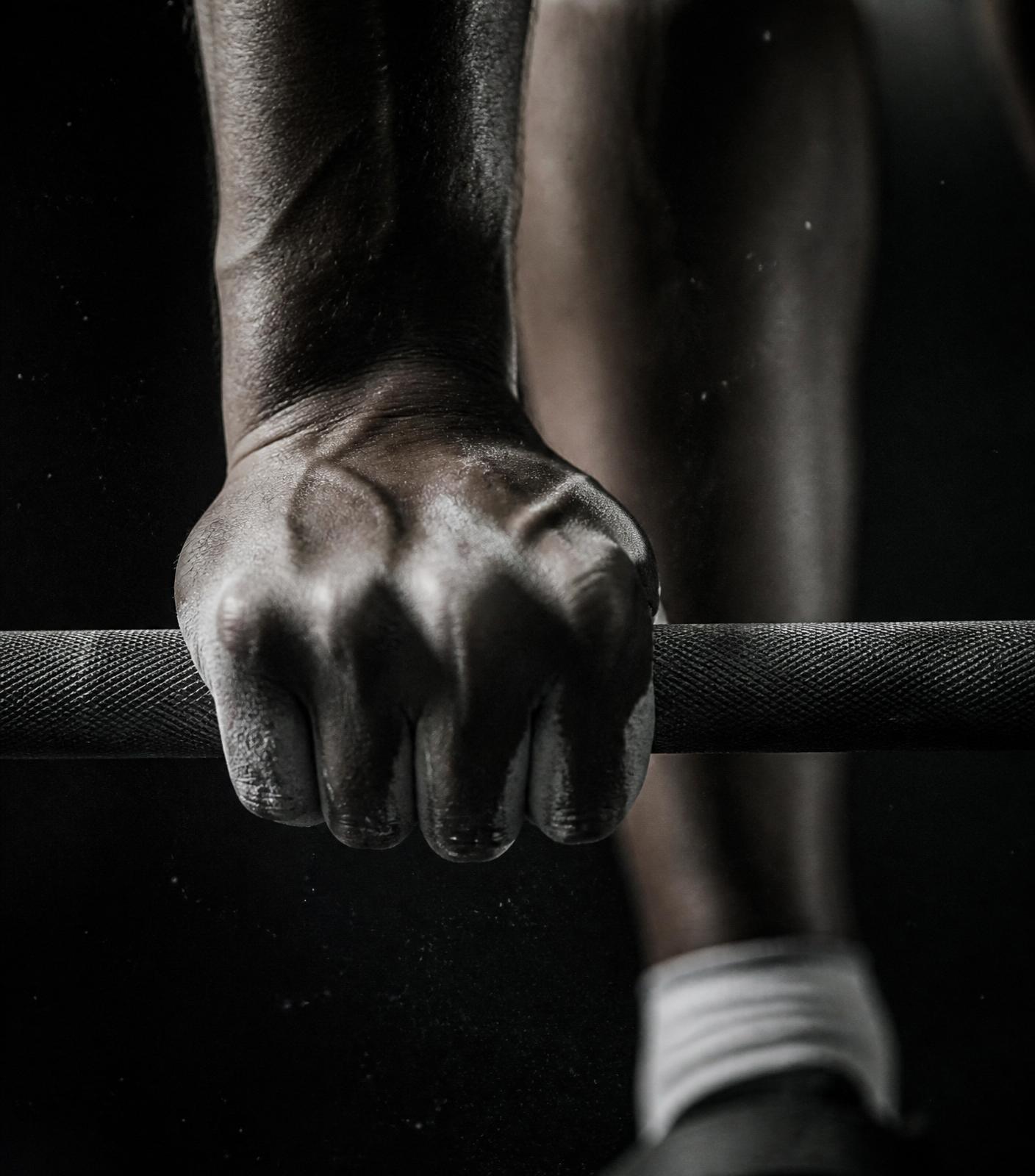 Mão de atleta segurando barra